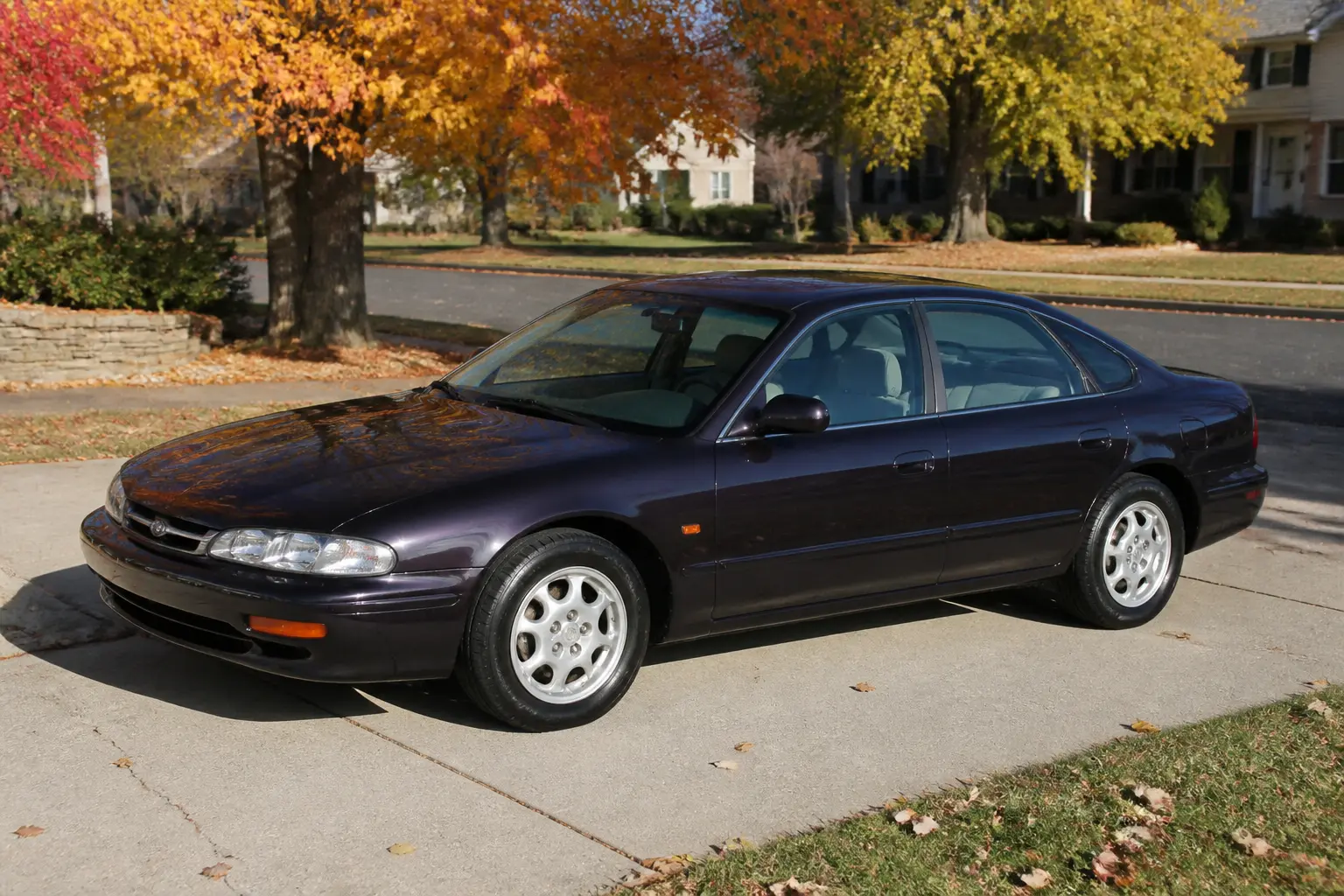 Infiniti J30 1993 року на під'їзній доріжці заміського будинку восени