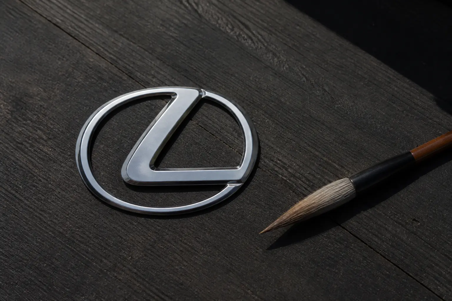 Эмблема Lexus рядом с кистью для каллиграфии