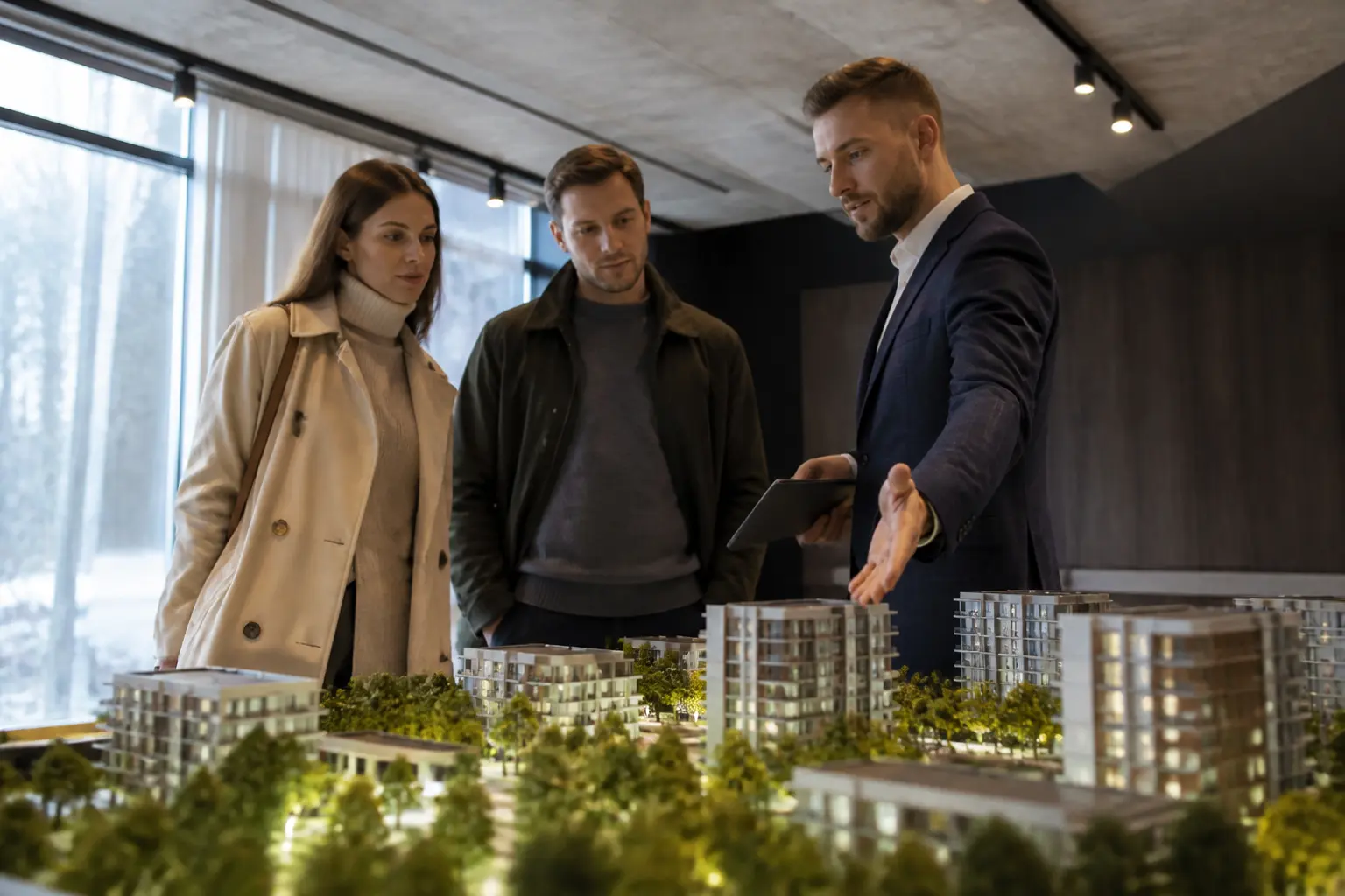 Пара розглядає макет житлового комплексу у відділі продажів