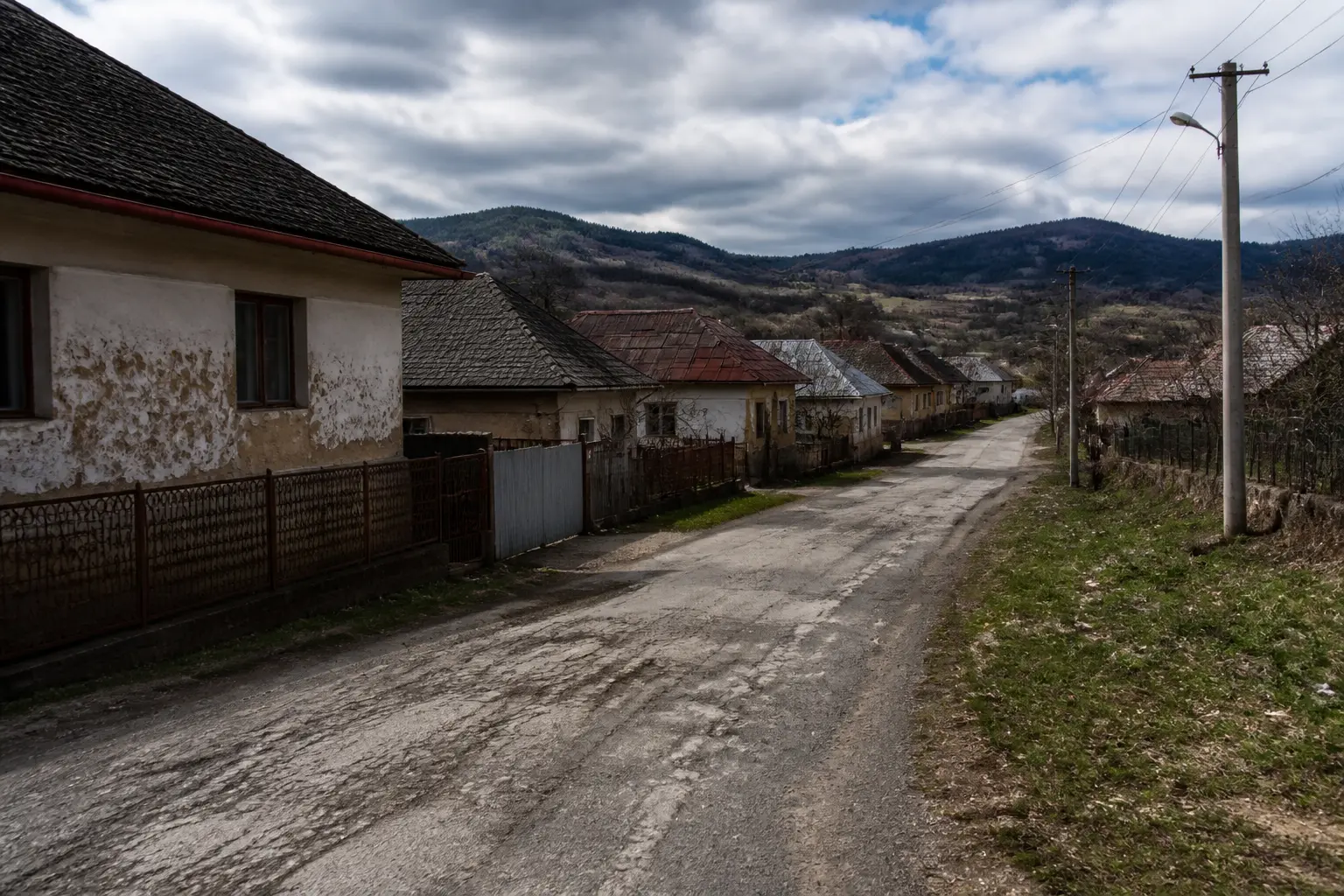 Сільська дорога на сході Словаччини з традиційними будинками та пагорбами