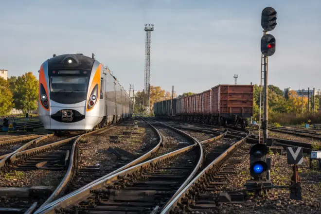 Пасажирський і вантажний поїзди на залізничних коліях