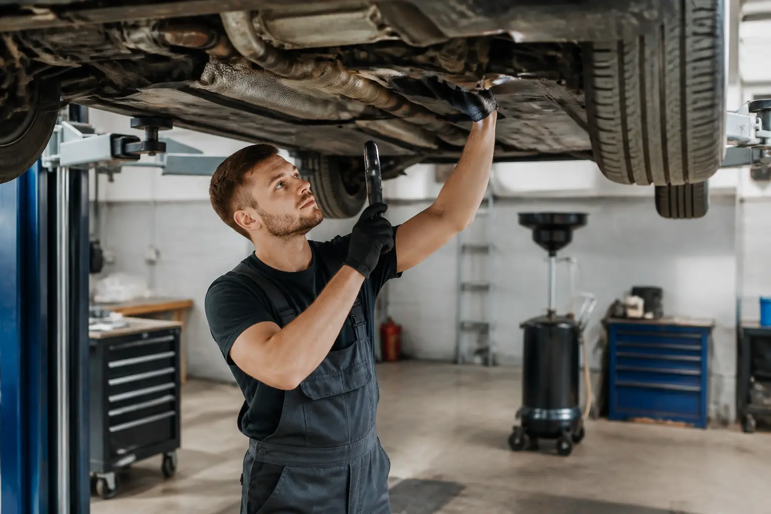 Автосервіс, механік оглядає автомобіль на підйомнику