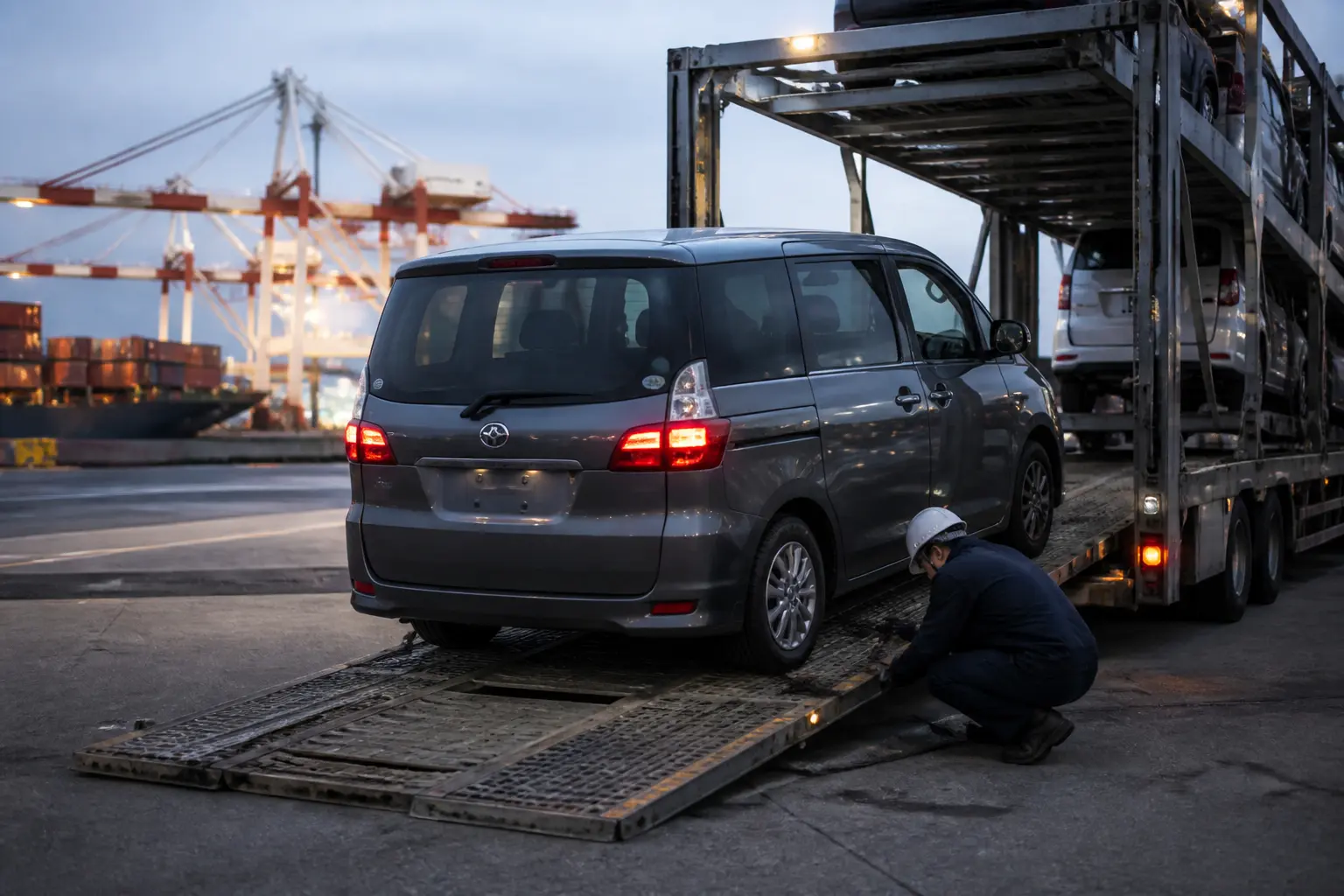 Автомобіль з Японії завантажують на автовоз біля морського порту